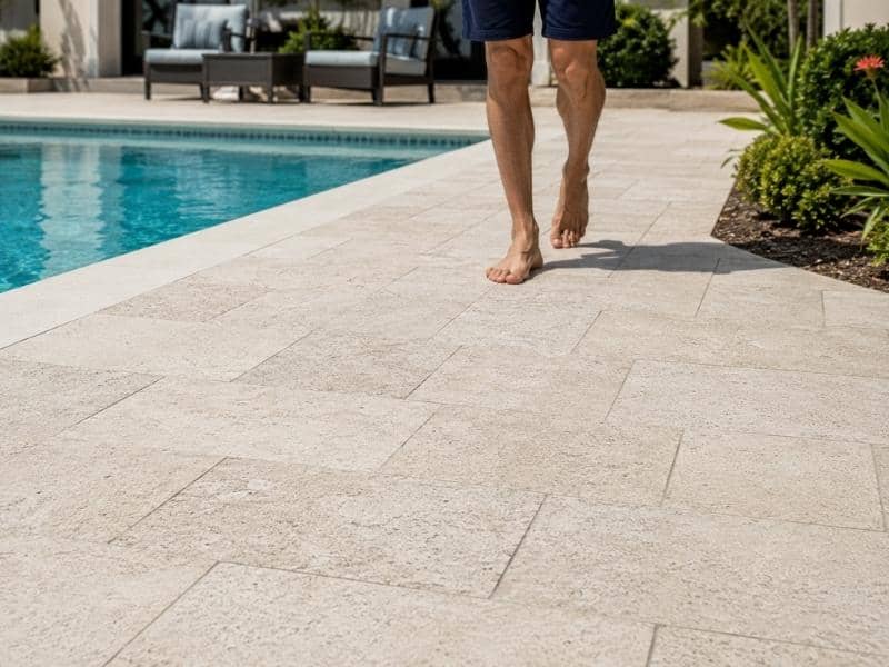 Stone pavers around a swimming pool in Fort Worth, TX with a textured, barefoot-friendly surface that provides traction, comfort, and effective drainage.