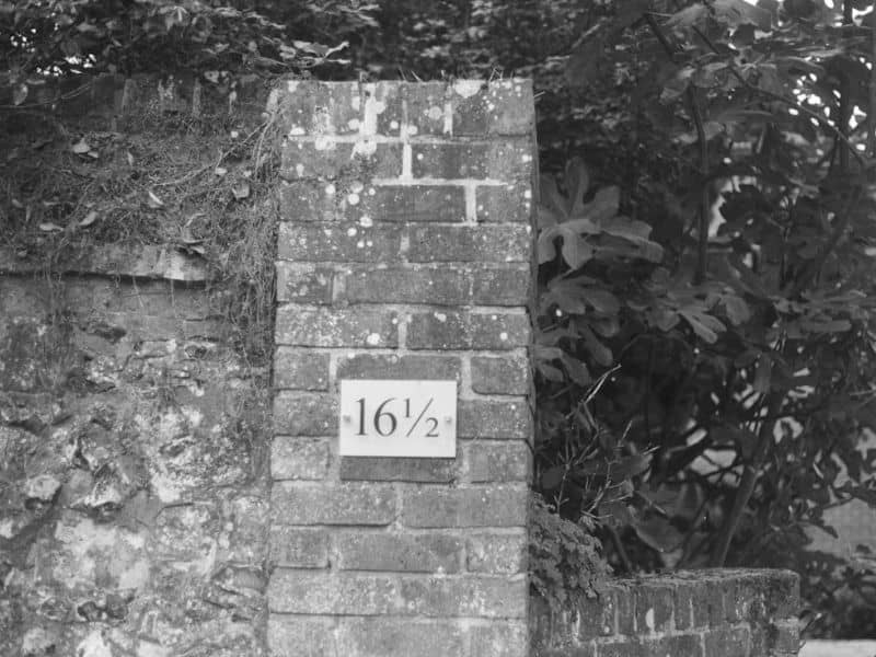 Brick mailbox with a clearly visible house number beside residential landscaping