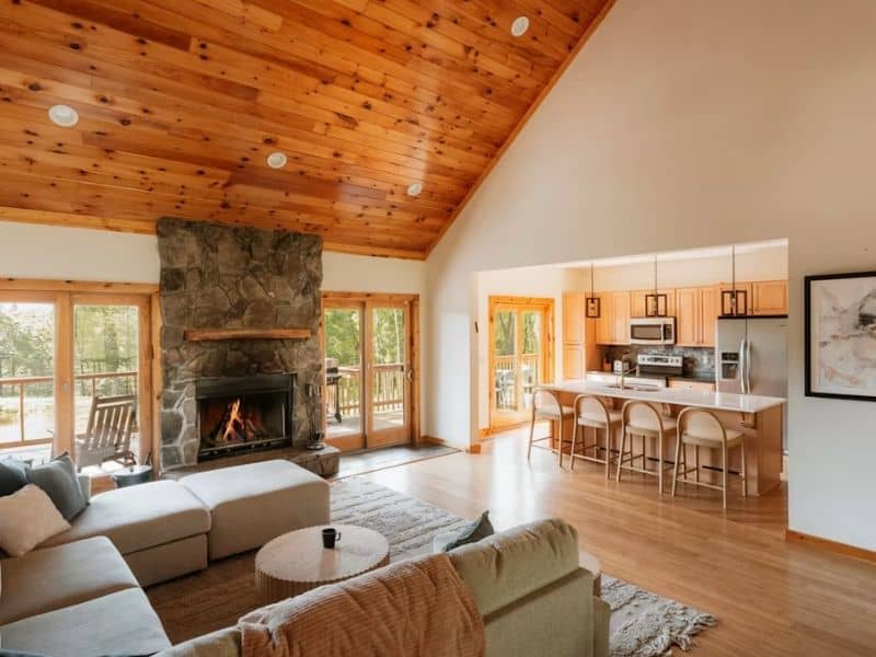 Stone fireplace and hardwood flooring illustrating a stone hearth extension in a residential living space