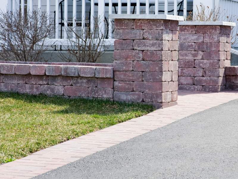 Brickmason constructing a curved brick entry wall at a residential property in Frisco, Texas.
