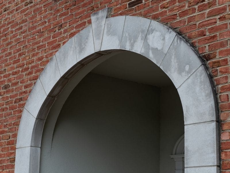 Brick arch over a doorway showing masonry support, lintel, curved opening, and surrounding brickwork.
